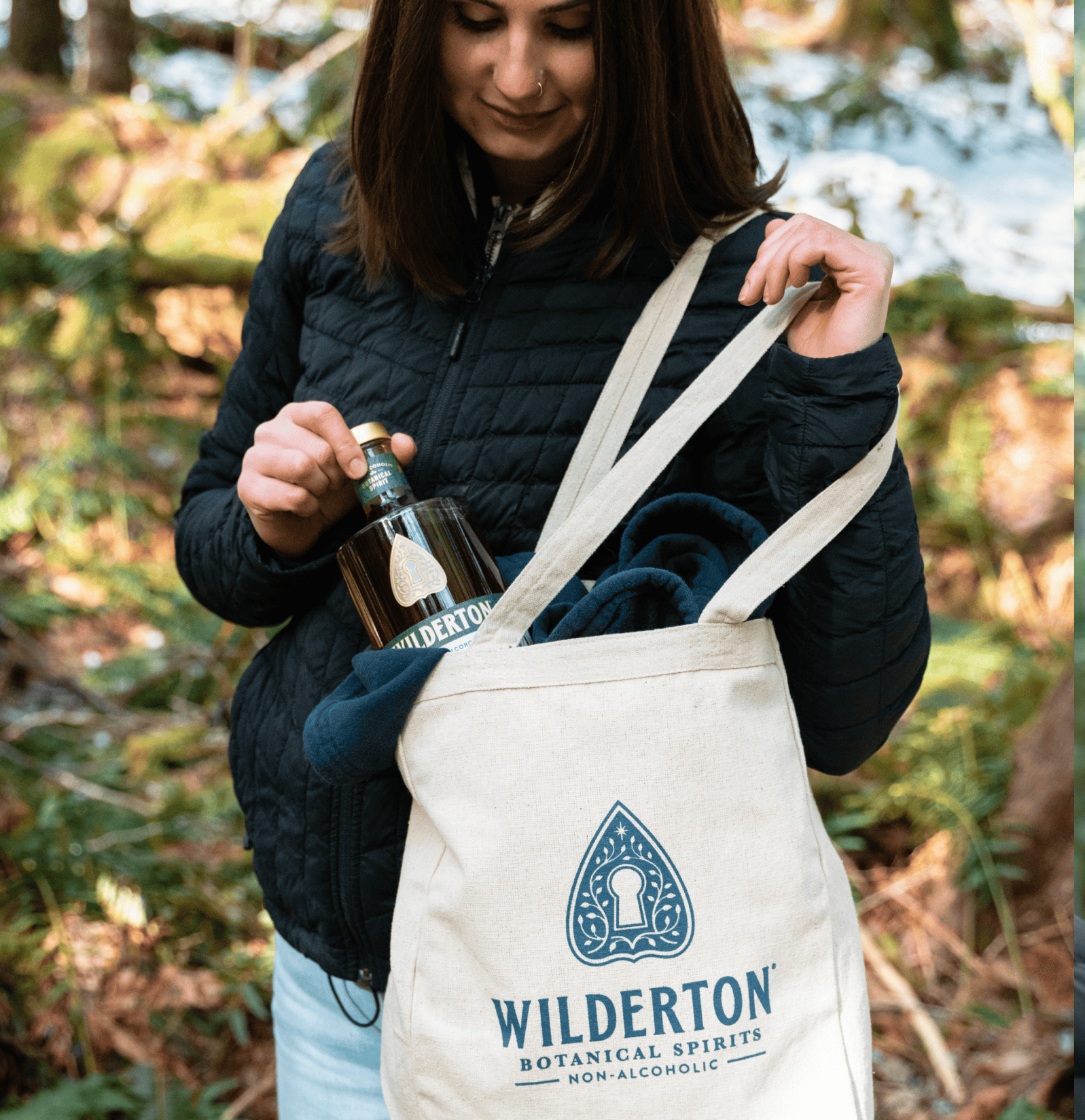 woman pulling a bottle of earthen from the wilderton tote